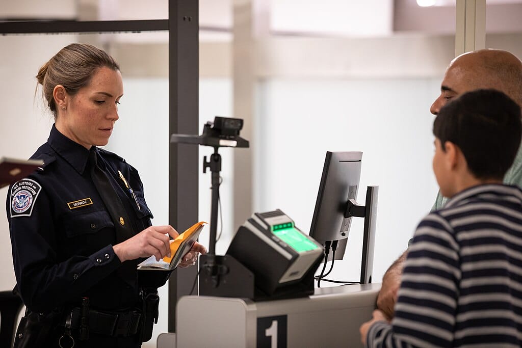 A CBP officer screens travelers at Miami International Airport.