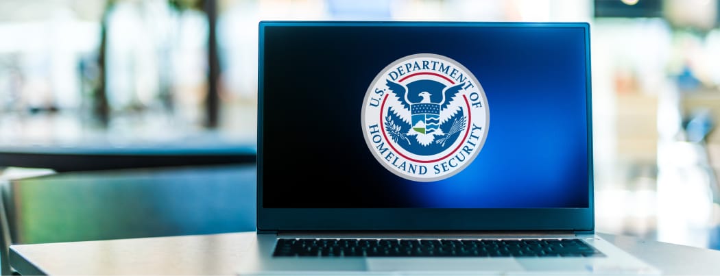 Laptop displaying logo of the US Department of Homeland Security AI Playbook 2025
