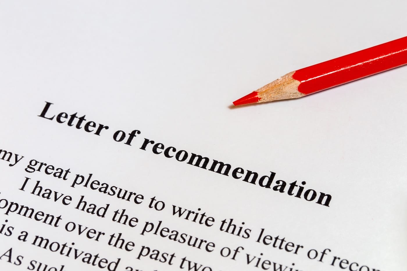 Close-up of printed immigration recommendation letter with black typed letters and a red colored pencil.